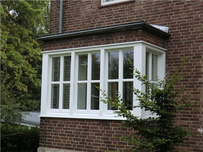 Weiße Holzfenster in einem Erker im Gebäudebestand